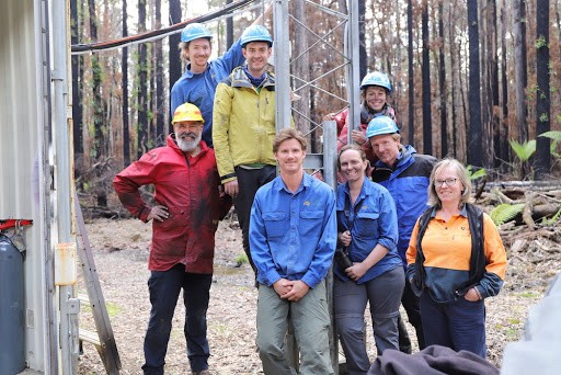 8 members of TERN’s Ecosystem Surveillance team in workwear in a forest