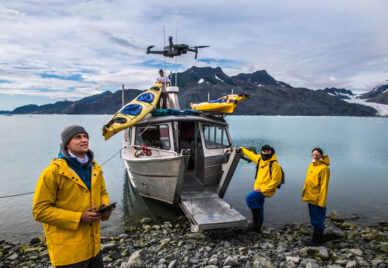 Man with crew members from scientific expedition  send a drone n