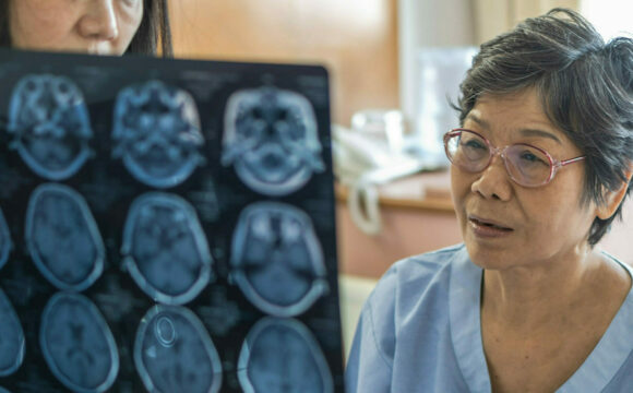 An elderly patient being shown an MRI scan by a health professional