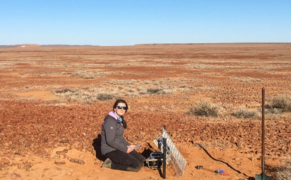 Dr Caroline Eakin working with in the field in a desert