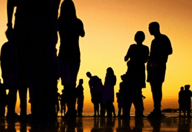 Silhouettes of a group of people on a beach at dusk