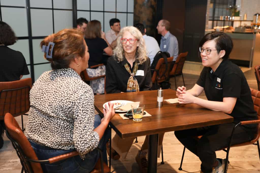 A R D C's Adeline Wong in a conversation with 2 attendees over light refreshments