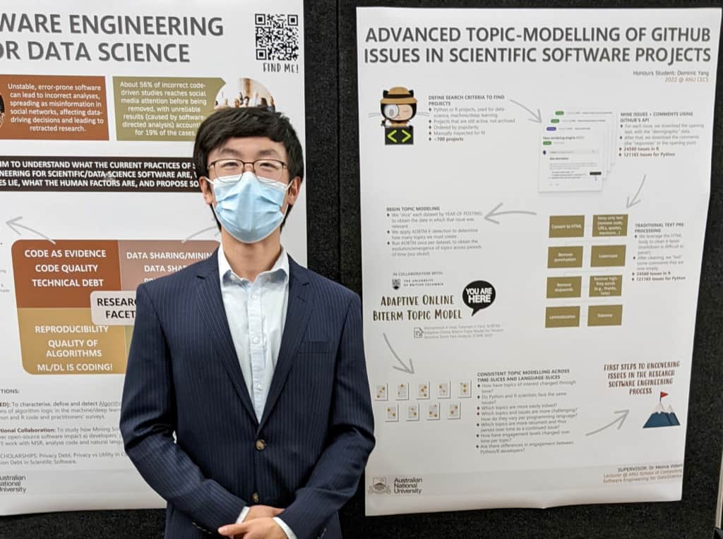 Dominic Yang  stands with his research presentation at the School of Computing at the ANU.