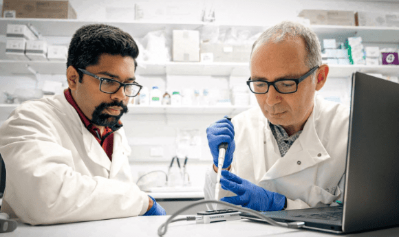 Dr Rahul Rane (left) and Dr Tom Walsh in a lab sequencing genomes of pest species.