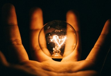 A floating light bulb in the palm of a hand