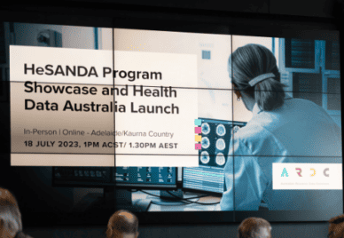 HeSANDA Program Showcase and Health Data Australia Launch - clinician looking at brain scan images in the background. Projected on a screen at a venue with tops of heads in the foreground.
