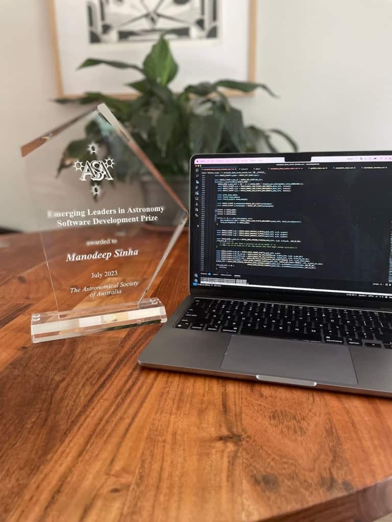 The polygonal crystal trophy for Manodeep’s Emerging Leaders in Astronomy Software Development Prize and a laptop displaying a  part of the Corrfunc code