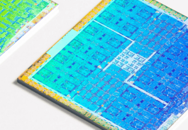 Three colorful GPUs with their packaging cleanly removed laying on a white surface