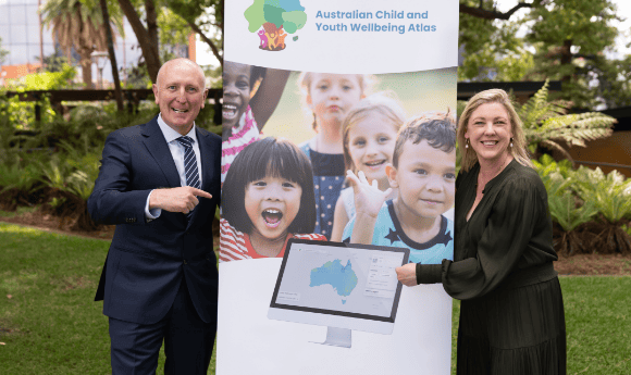 Australian Child and Youth Wellbeing Atlas banner with 2 people either side of it with a green leafy background.