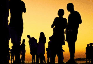 Silhouettes of people on a beach at dawn or dusk