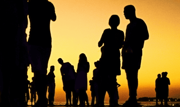 Silhouettes of people on a beach at dawn or dusk